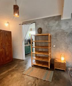 Zimmer mit einer Wand mit einem Regal und einem Tisch in der Unterkunft Vertical House Bali in Uluwatu