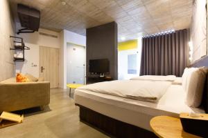 YZ SPA House في جياوكسي: غرفة نوم بسرير ابيض كبير واريكة