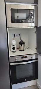 a kitchen with a microwave and a stove at Las Gaviotas in Viveiro