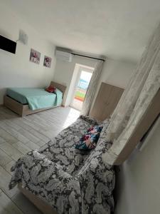 a bedroom with a bed and a window at Agriturismo Un Mare di Fiori in Ventimiglia
