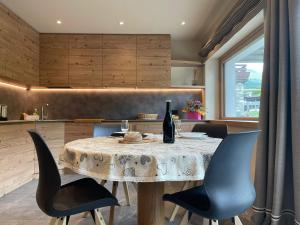 a kitchen with a table with chairs and a bottle of wine at Casa Lalla in Bormio