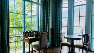 a desk in a room with a large window at Faraway Cottages, Auli in Joshīmath
