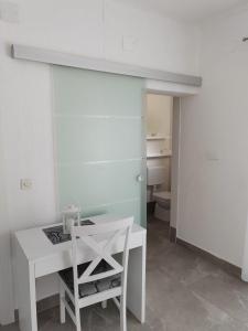 een witte tafel en stoel in een kamer met een toilet bij Plaza 1 in Sveti Juraj