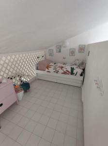 ein kleines Schlafzimmer mit einem Bett und einem gefliesten Boden in der Unterkunft Emerald Cottage Calaverde Santa Margherita di Pula in Fort Village