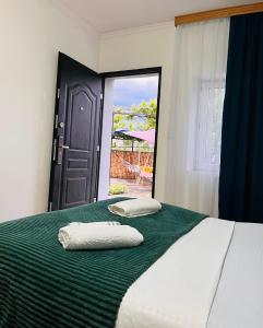 1 dormitorio con 2 almohadas en una cama con ventana en Hotel Sunny, en Akhaltsikhe