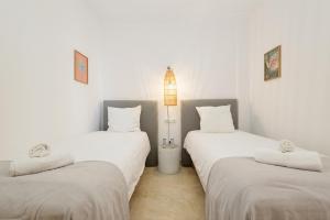 Pokój z 2 łóżkami z białą pościelą i lampą w obiekcie Modern and luxurious holiday home with sea views in Benahavís w mieście Estepona