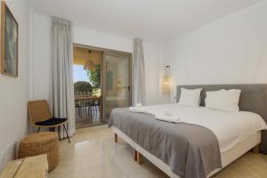 sypialnia z dużym łóżkiem i balkonem w obiekcie Modern and luxurious holiday home with sea views in Benahavís w mieście Estepona