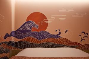 uma onda no oceano com um sol nascente em Yatomi Hotel Nuqu Natural Hot Spring 