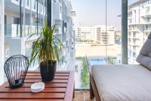 a balcony with a bed and a plant on a table at Industrial Chic Retreat in Al Qurayyah