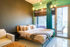 a bedroom with a bed and a chair and a window at Industrial Chic Retreat in Al Qurayyah