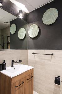 a bathroom with a sink and a mirror at Industrial Chic Retreat in Al Qurayyah