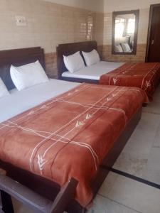 a row of three beds in a room at hotel sunny international in Jammu