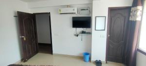 a room with a door and a television on the wall at hotel sunny international in Jammu