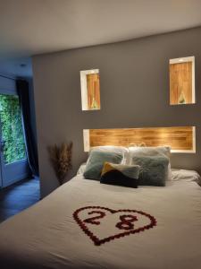 Un dormitorio con una cama con un corazón. en "Levasion romantique" loft jacuzzi jardin privatif près de Paris en Saint-Prix