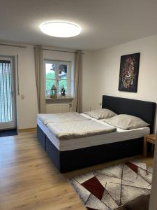- une chambre avec un grand lit et une fenêtre dans l'établissement Ferienwohnung Parzinger 2, à Chieming