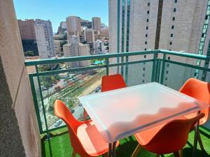 stół i krzesła na balkonie z widokiem na miasto w obiekcie Precioso apartamento con piscina cerca de la playa w mieście Benidorm