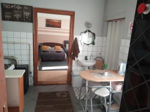 - une petite salle de bains avec un lit, une table et un lavabo dans l'établissement Passion Apartment, à Pécs