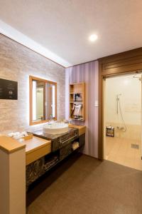 ein Badezimmer mit einem großen Waschbecken und einer Dusche in der Unterkunft Yatomi Hotel Nuqu Natural Hot Spring 