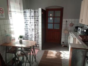 - une petite cuisine avec une table et une porte dans l'établissement Passion Apartment, à Pécs