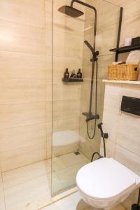 a shower with a toilet and a glass shower stall at Poolside Charm in Abu Dhabi