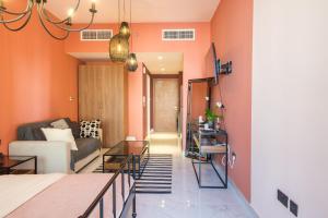 uma sala de estar com paredes cor de laranja e um sofá em Poolside Charm em Abu Dhabi