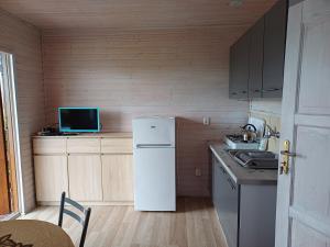 a small kitchen with a white refrigerator and a table at Wichrowa Skarpa in Rusinowo