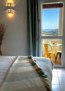 a bedroom with a bed and a window and a table at Les Vigies-T4 au calme-vue mer-terrasse-Parking in Collioure