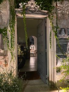 an open door into a hallway with ivy at La maison sur la place in Penne-dʼAgenais