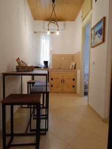 a kitchen with a table and chairs and a sink at Athina Studio Apartments in Kerveli