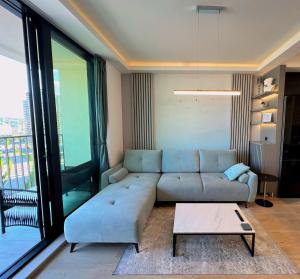 een woonkamer met een bank en een tafel bij Belgrade Waterfront 10th fl Lux Apt. w/ City view in Belgrado