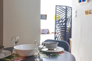 アテネにあるUnique studio at Athens Riviera 1 min from the seaのワイングラス2杯とボウル1杯付きのテーブル