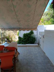 un patio con tenda, tavolo e sedie. di Athina Studio Apartments a Kerveli
