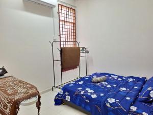 1 dormitorio con 1 cama con edredón azul en IBRAHIM’S HOMESTAY en Kuala Kerai