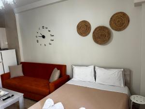 1 dormitorio con cama, reloj y sofá en Central House Karistos en Karistos