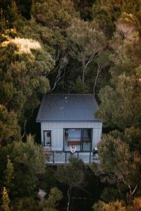 a woman standing in the window of a small house at Treehouse Hideaway in Opua
