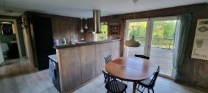 a kitchen and dining room with a wooden table at Svensk skovhytte in Norra Emmeboda