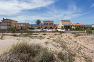 una hilera de casas en la playa en la arena en Villa Rosa 2, en Oliva