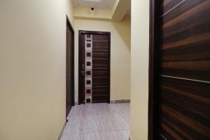 um corredor com uma porta castanha e piso em azulejo em FabHotel Magadh Palace em Patna
