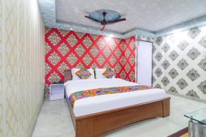 sypialnia z łóżkiem i czerwoną ścianą w obiekcie FabHotel Magadh Palace w mieście Patna