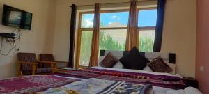 una camera con un letto e una grande finestra di Hotel Malik Residency a Leh