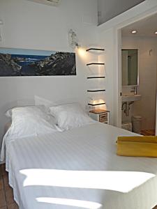 a bedroom with a white bed and a sink at L'Hostalet de Cadaques in Cadaqués