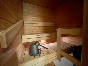 a small sauna with a pot in the middle at Kotimaailma Apartments Lahti in Lahti