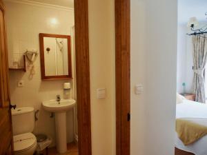a bathroom with a sink and a toilet and a mirror at Apartamentos Remoña 1 in Espinama
