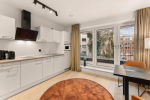 奥尔登堡BeTween Studios的带白色橱柜和桌子的厨房和餐厅