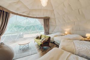 a room with two beds and a large window at LUONTE 霧の高原 Glamping 
