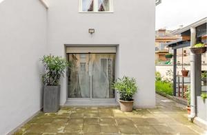 una casa bianca con due piante in vaso davanti a una porta di Maisonnette avec terrasse a Strasburgo
