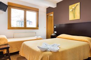 A bed or beds in a room at Hotel San Lázaro