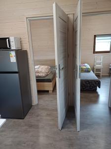 a room with two open doors and a refrigerator at Wichrowa Skarpa in Rusinowo
