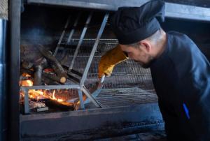 a man is cooking food in an oven at Hostal el secreto in Teruel