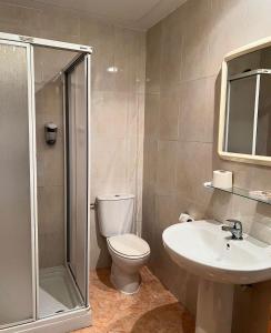 a bathroom with a toilet and a sink and a shower at Hostal el secreto in Teruel